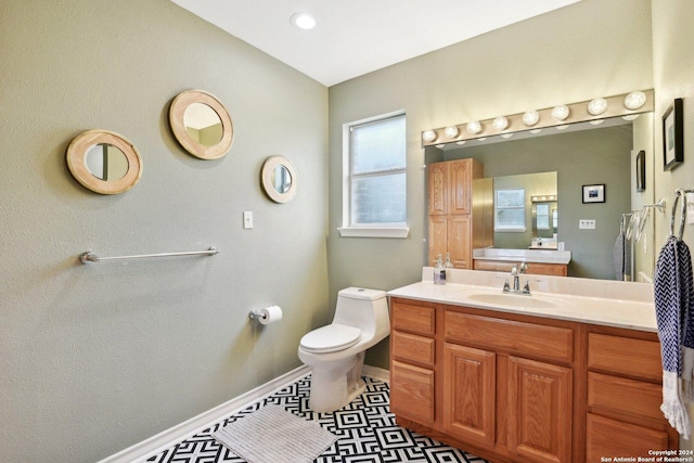 bathroom with toilet, vanity, and tile patterned floors