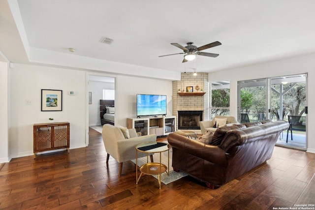 living room featuring dark hardwood / wood-style floors, ceiling fan, and a fireplace