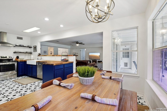 dining room featuring ceiling fan with notable chandelier and sink