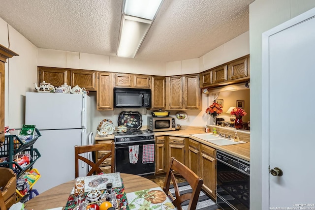 kitchen with black appliances, sink, and a textured ceiling