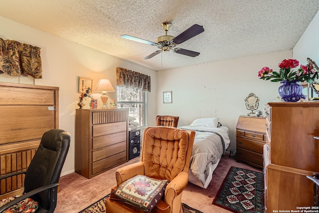 carpeted bedroom with ceiling fan and a textured ceiling