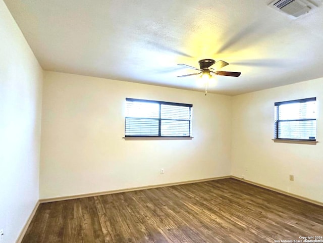 spare room featuring ceiling fan and dark wood-type flooring