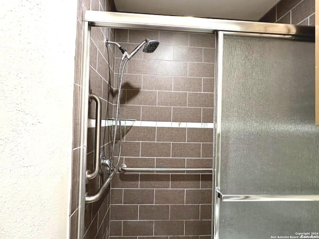 bathroom with a shower with door