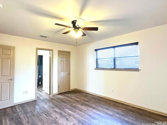 unfurnished bedroom featuring ceiling fan and dark wood-type flooring