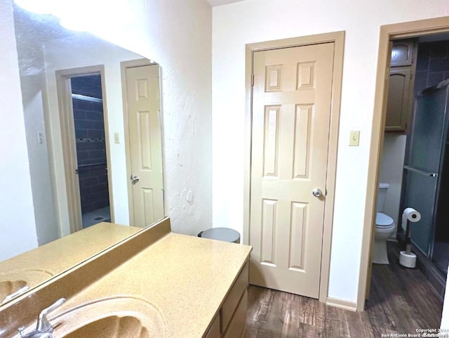 bathroom with hardwood / wood-style floors, vanity, and toilet