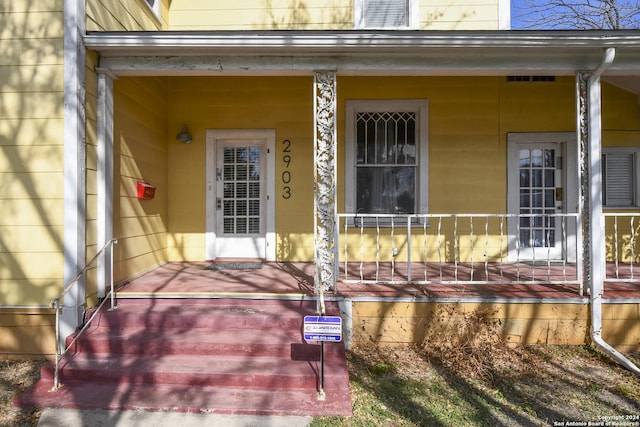 view of exterior entry featuring covered porch