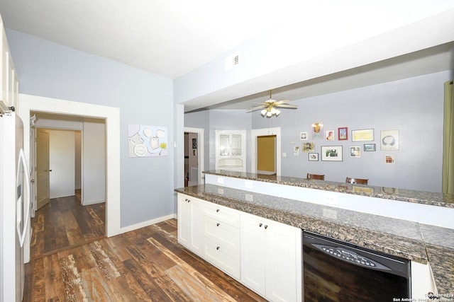 kitchen with dark hardwood / wood-style flooring, white refrigerator, dark stone countertops, black dishwasher, and white cabinetry