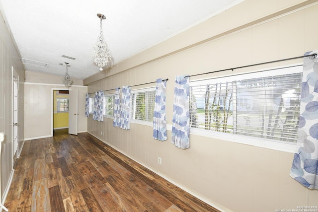 interior space featuring lofted ceiling, dark wood-type flooring, a textured ceiling, and a notable chandelier