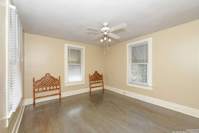 unfurnished room with plenty of natural light, dark hardwood / wood-style floors, and ceiling fan