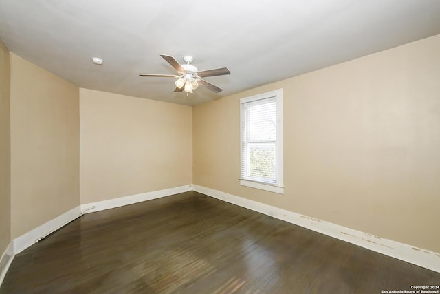 empty room with ceiling fan and dark wood-type flooring