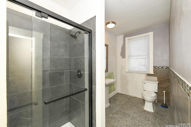 bathroom with an enclosed shower, toilet, and tile walls