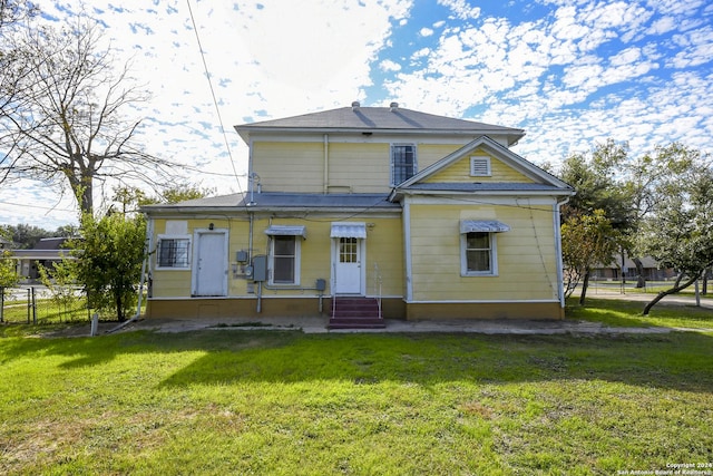 rear view of property featuring a yard