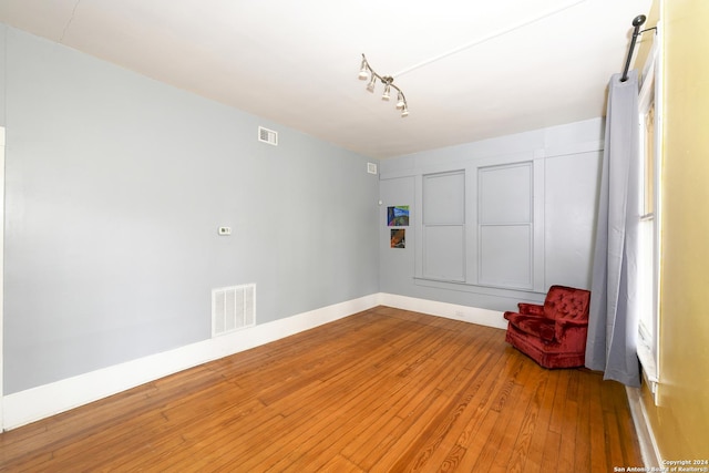 unfurnished room with hardwood / wood-style flooring