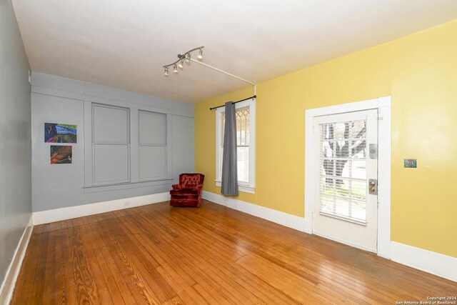 unfurnished room featuring hardwood / wood-style flooring and a healthy amount of sunlight