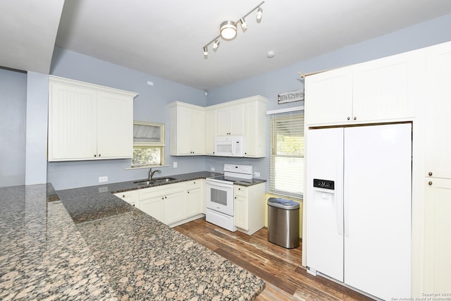 kitchen featuring dark stone counters, white appliances, dark wood-type flooring, sink, and white cabinetry