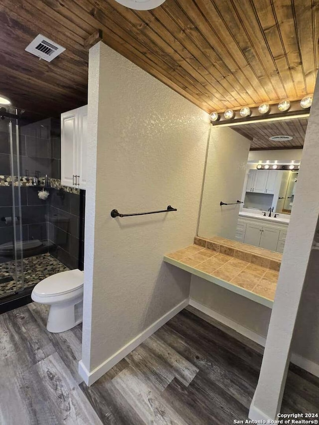 bathroom featuring wood-type flooring, toilet, walk in shower, and wooden ceiling