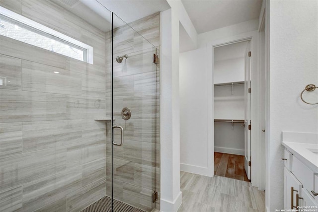 bathroom with hardwood / wood-style flooring, vanity, and an enclosed shower