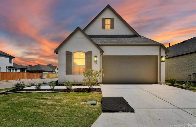 view of front of home featuring a garage and a yard