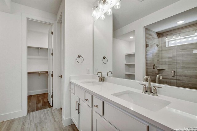 bathroom with a shower with shower door and vanity