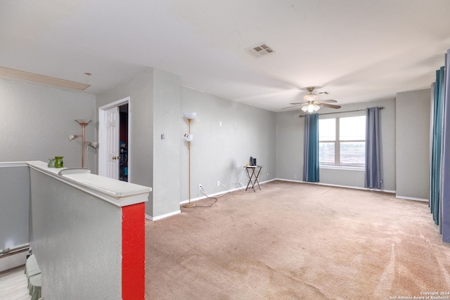 spare room with ceiling fan, light colored carpet, and a baseboard heating unit