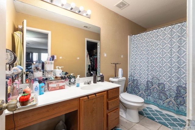 bathroom featuring toilet, vanity, tile patterned floors, and curtained shower