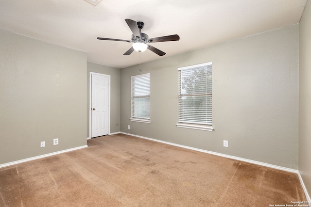 carpeted spare room with ceiling fan