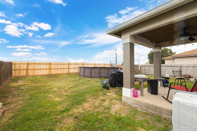 view of yard with ceiling fan and a patio