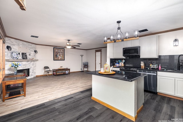 kitchen featuring hanging light fixtures, white cabinetry, dishwasher, and dark wood-type flooring