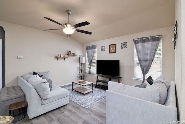 living room with ceiling fan, light hardwood / wood-style floors, and vaulted ceiling