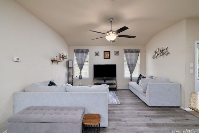 living room featuring ceiling fan, a healthy amount of sunlight, light wood-type flooring, and vaulted ceiling