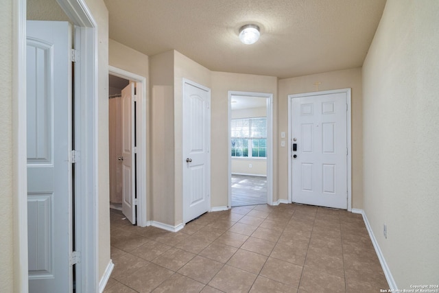 tiled entryway featuring a textured ceiling