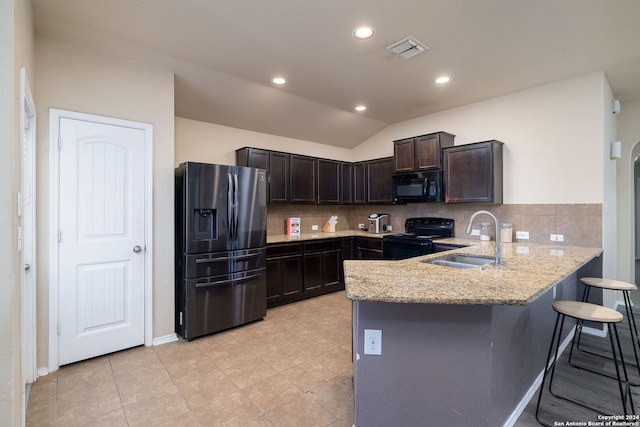 kitchen featuring lofted ceiling, backsplash, black appliances, sink, and kitchen peninsula