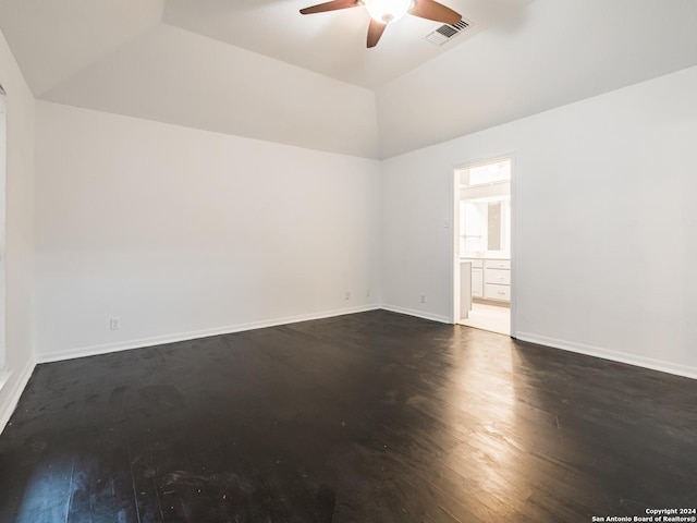 spare room featuring ceiling fan, dark wood-type flooring, and vaulted ceiling