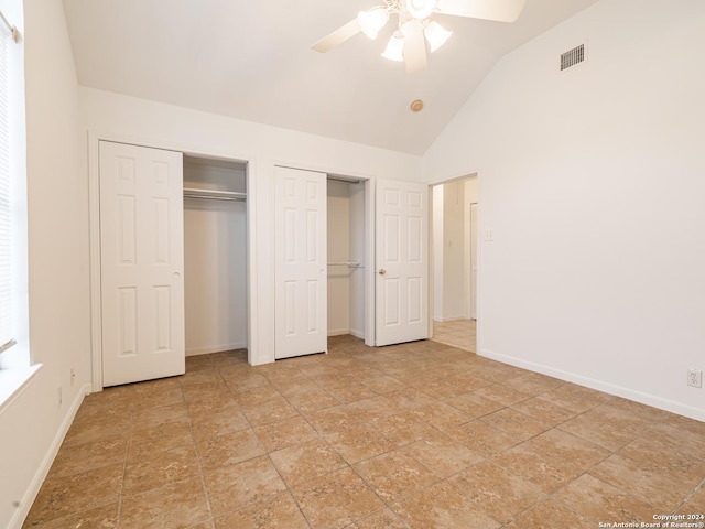 unfurnished bedroom with two closets, ceiling fan, and lofted ceiling