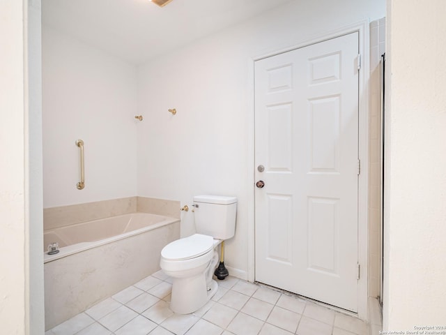 bathroom featuring tile patterned flooring, a bathtub, and toilet