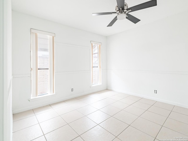 spare room with ceiling fan and light tile patterned floors