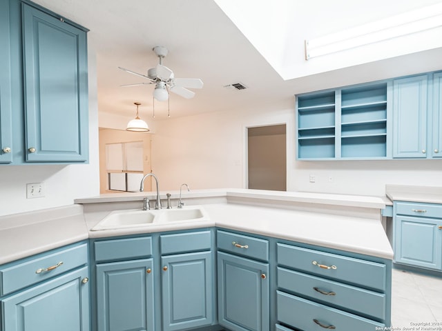 kitchen featuring blue cabinetry, kitchen peninsula, ceiling fan, and sink