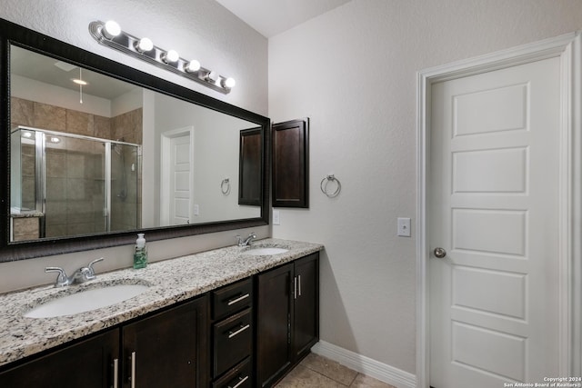 bathroom featuring tile patterned floors, a shower with door, and vanity