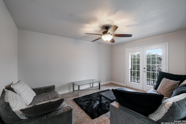 carpeted living room with ceiling fan, a textured ceiling, and french doors