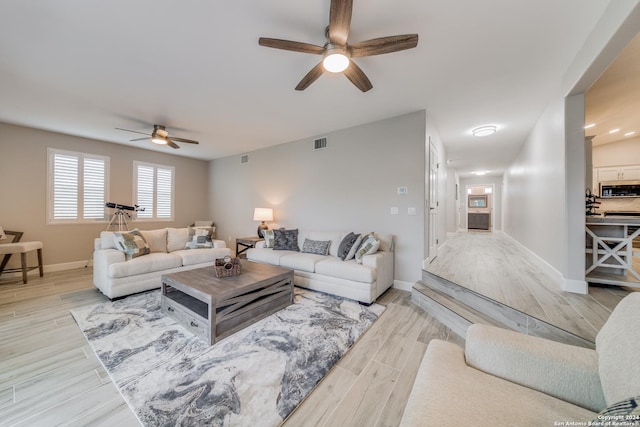 living room with ceiling fan and light hardwood / wood-style floors