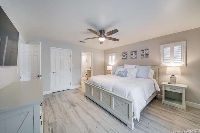 bedroom featuring ceiling fan, ensuite bath, and light hardwood / wood-style flooring