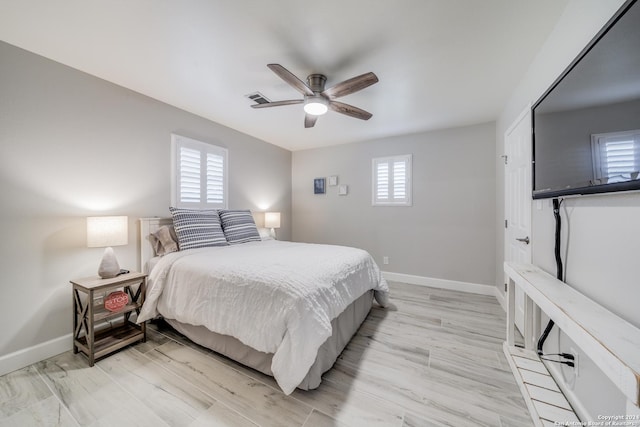 bedroom featuring multiple windows, ceiling fan, and light hardwood / wood-style floors