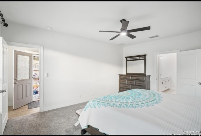 bedroom with ensuite bathroom, ceiling fan, and light colored carpet