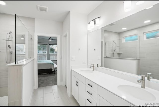 bathroom featuring a tile shower, vanity, tile patterned floors, and ceiling fan