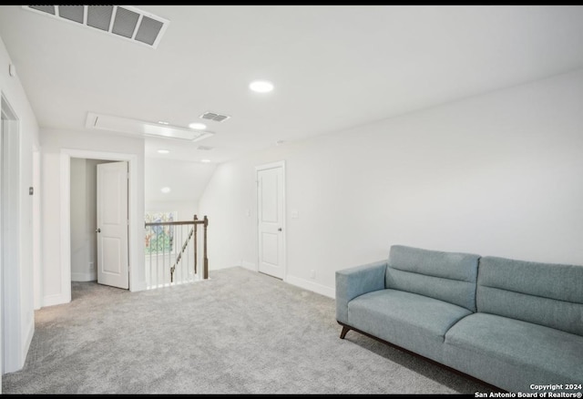 sitting room featuring light carpet and vaulted ceiling