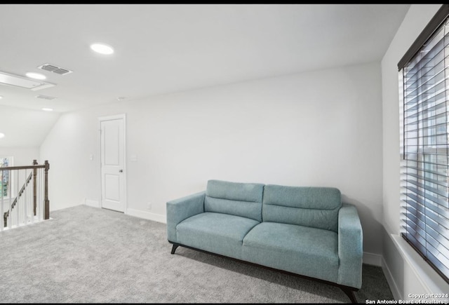 sitting room with carpet floors and vaulted ceiling