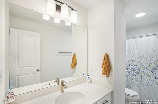 bathroom with vanity, toilet, and curtained shower