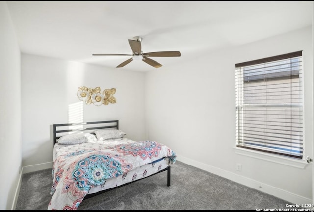 bedroom featuring dark colored carpet, ceiling fan, and multiple windows