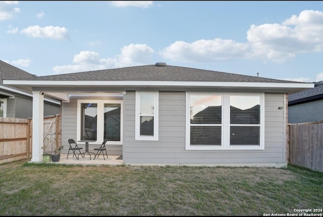 rear view of house with a yard and a patio