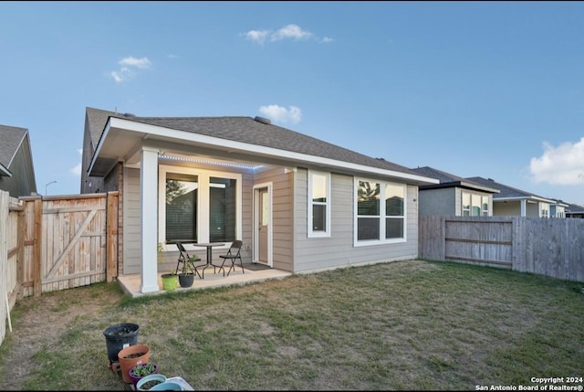 rear view of property with a patio area and a lawn